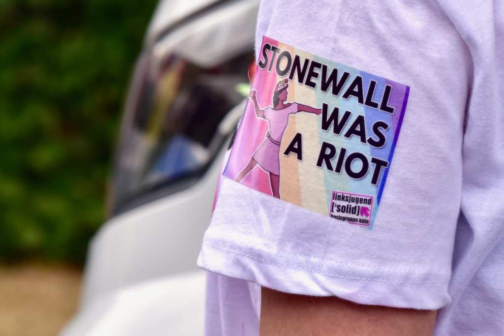 「Stonewall was a riot」とデザインされたTシャツの袖