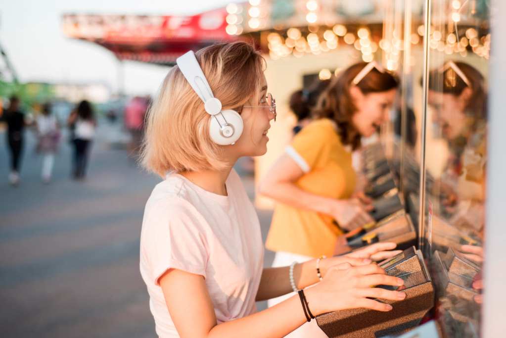 音に敏感なためヘッドフォンを着けた女性が遊園地で楽しい時間を過ごしている様子